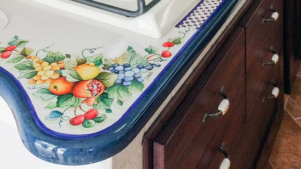 Lava stone kitchen worktop with blue edge and hand-painted pomegranate decoration