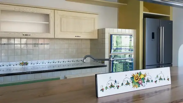 Moderna kitchen: island with a wooden breakfast counter and decorated floral panel