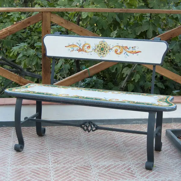 Iron bench with hand-decorated lava stone seat and backrest.