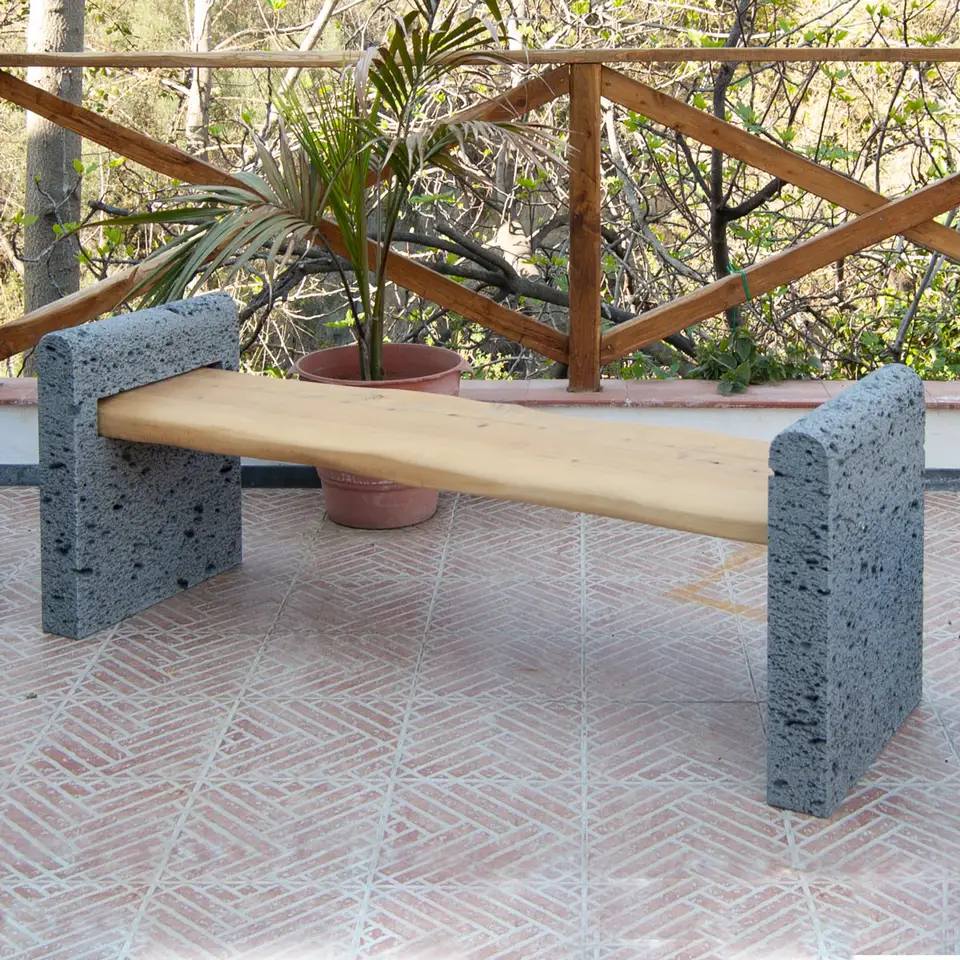 Bench with solid wood seat and side walls in bush-hammered lava stone.