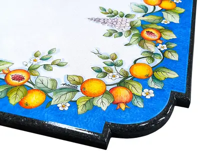 Detail of a hand-decorated lava stone table with pomegranate and wisteria painting