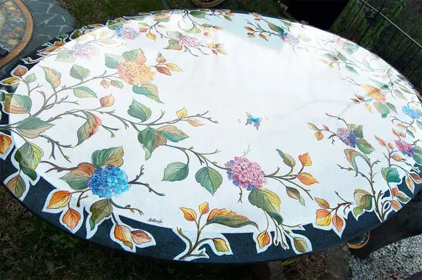 Oval lava stone table with wide polished edge and hand-decorated top