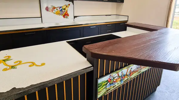 Cocina Via Veneto: isla con encimera decorada, panel de listones Cocina Via Veneto: isla con encimera decorada, panel de listones y barra de desayuno de madera