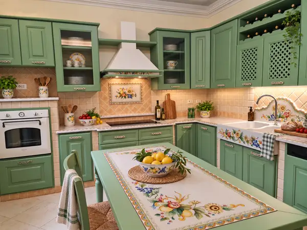 Cocina angular Siracusa verde salvia Cocina angular Siracusa con puertas verde salvia, horno elevado y mesa con motivos de frutas y flores