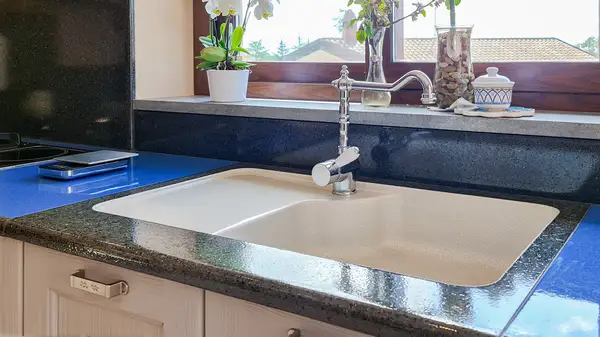 Pisa kitchen: inset single-bowl sink with a dark countertop surround
