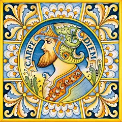 Decorated tile with a male profile portrait wearing a decorated helmet, the words Carpe Diem and a blue, white and yellow floral frame