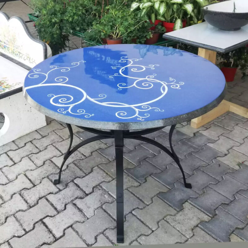 modern table in lava stone decorated by hand, blue background with white decoration